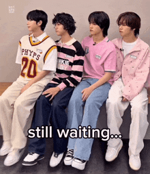 a group of young men are sitting next to each other and the words still waiting are visible