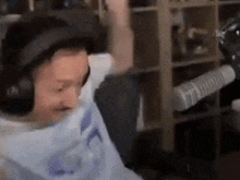 a man wearing headphones is sitting in front of a microphone in a living room .