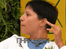 a woman with short hair is covering her ear with her finger and the word phra oesh is on the bottom