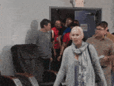 a group of people standing in front of an exit sign that says " emergency exit "