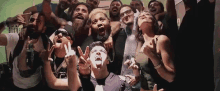 a group of people are posing for a picture together while making funny faces .