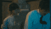 a man and a woman standing next to each other in a dark room