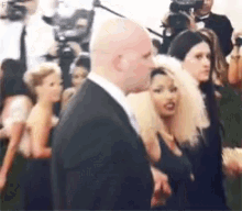 a man in a suit and tie is standing in a crowd of people .
