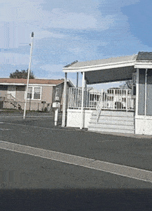 a mobile home with a porch and stairs on the side of the road