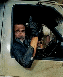 a man wearing leather gloves is giving a thumbs up