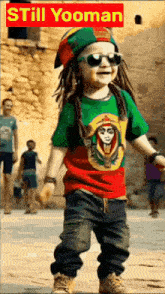 a young boy wearing sunglasses and a rasta hat is standing in front of a sign that says still yooman on it