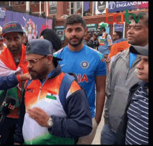 a man wearing a shirt that says india stands in a crowd
