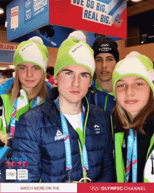 a group of people posing for a photo with the olympic channel in the upper right corner