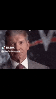 a man in a suit and tie is clapping .