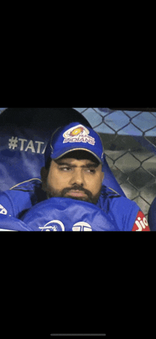 a man wearing a blue hat that says indians