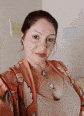 a woman is taking a selfie with a necklace around her neck .