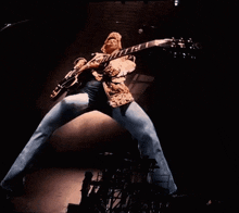 a man is playing a guitar with the word gibson on the neck