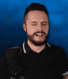 a man with his eyes closed singing into a microphone