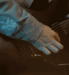a close up of a person 's hand playing a guitar .