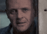 a close up of a man 's face looking out a window