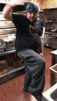 a man is dancing in a kitchen with a sign that says senior on it