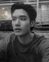 a black and white photo of a young man wearing a t-shirt that says adidas on it