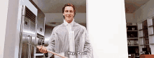 a man in a white coat is holding a wooden stick and saying hey paul .