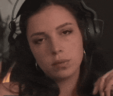 a close up of a woman wearing headphones looking at the camera