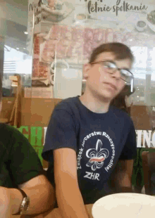 a young boy wearing glasses and a shirt that says zhr