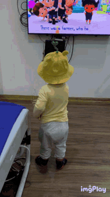 a child is standing in front of a tv that says there was a farmer who he on it