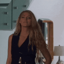 a woman in a black dress stands in front of a mirror