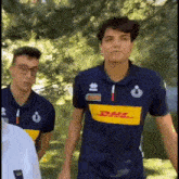 a man wearing a blue shirt with dhl on the front