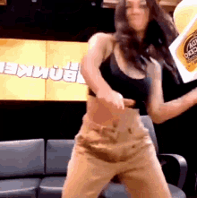 a woman is dancing in front of a sign that says bomber