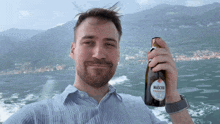 a man holds a bottle of maschio prosecco in his hand