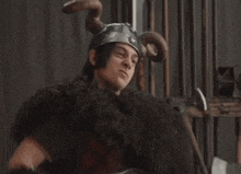 a man in a viking costume is flexing his muscles while holding a spiked mace
