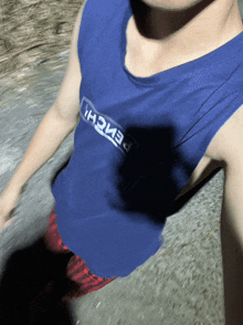a man wearing a blue tank top that says bench