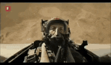 a man wearing a helmet and goggles is flying a fighter jet .