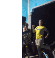 a woman in a yellow nike shirt is standing in front of a blue wall