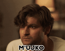 a man in a white shirt has the word mujko written on his face