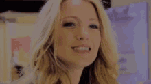 a close up of a woman 's face with blonde hair looking at the camera .