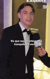 a man in a suit and bow tie is being interviewed by a reporter