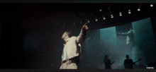 a man is singing into a microphone on a stage in a video for vevo