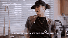 a woman in a kitchen with the words it 's a competition at the end of the day