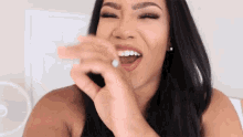 a woman with a ring on her finger is laughing with her mouth open