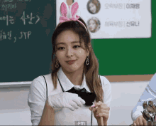 a girl wearing a headband with a bunny ear and gloves says pfft