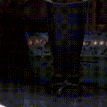 a cartoon character is sitting in a chair with a blue light coming out of his mouth