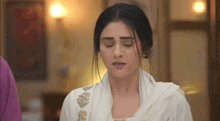 a woman in a white dress is making a funny face .