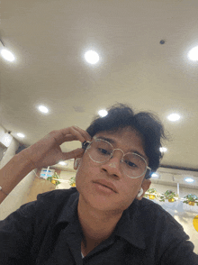 a young man wearing glasses and a black shirt