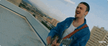 a man playing a guitar with the word vevo on the bottom right