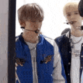 a group of young men are standing next to each other and one of them is wearing a microphone .