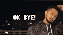a man with a beard is standing in front of a sign that reads ok bye