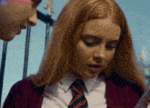 a girl in a school uniform is looking at a piece of paper with a discord logo in the corner