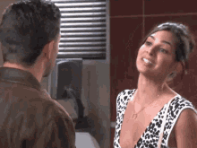 a man and a woman are looking at each other and the woman is smiling