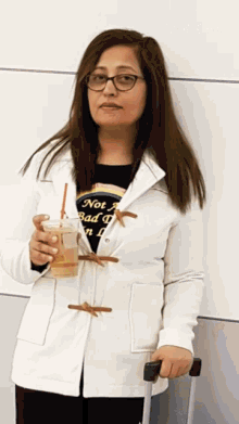a woman holding a drink wearing a shirt that says not a bad day in l.