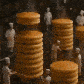 a stack of pancakes being made in a bakery by a group of chefs .